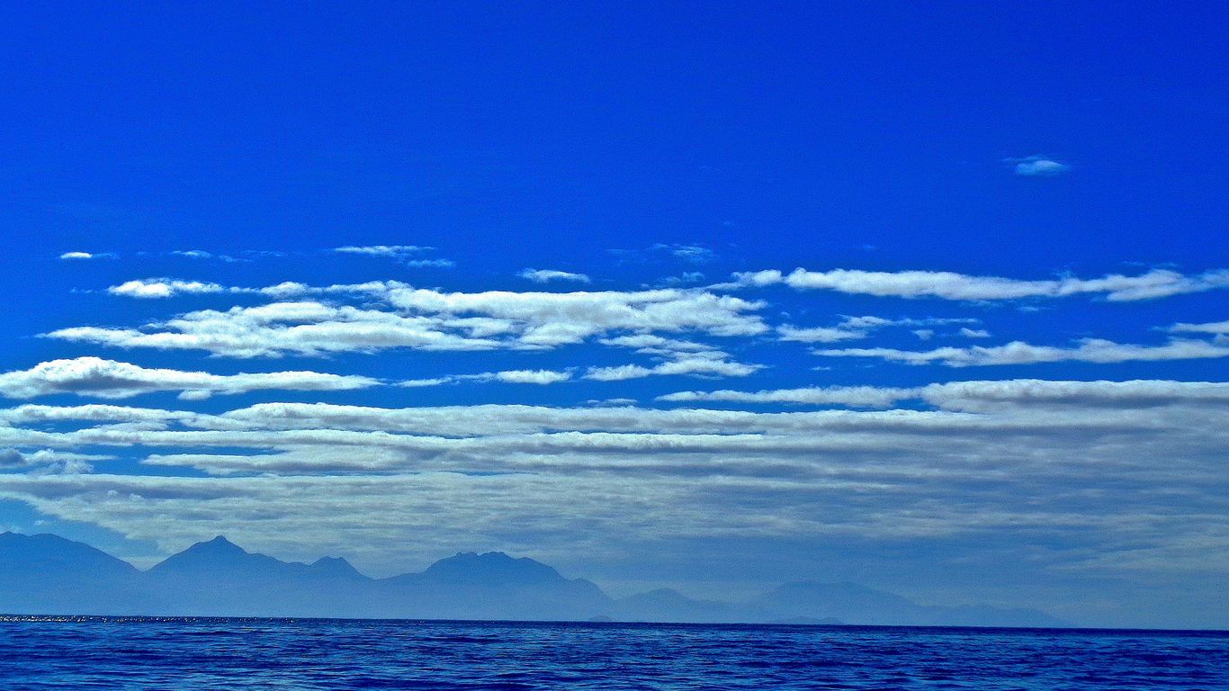 a large body of water with mountains in the background