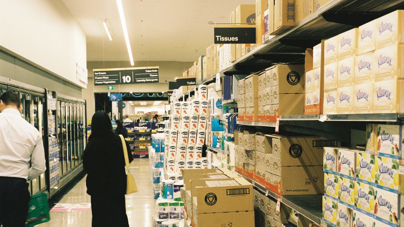a woman walking down a aisle in a store