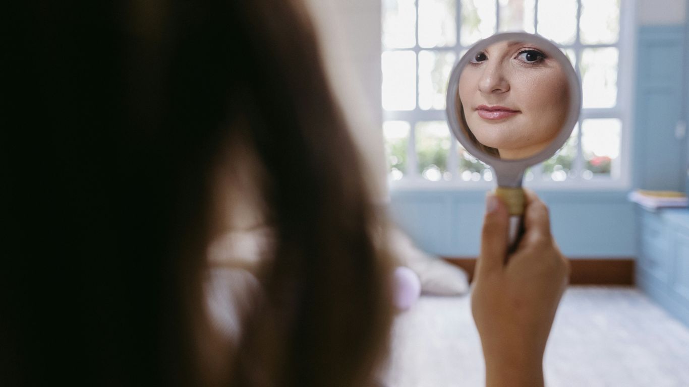 a woman looking at herself in the mirror