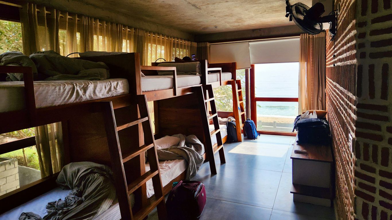 a room filled with lots of bunk beds next to a window
