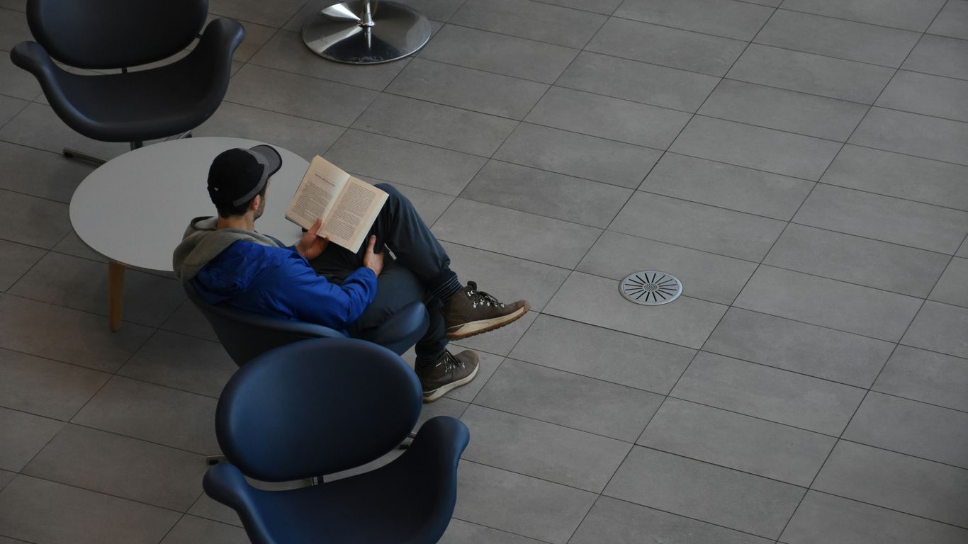 A man sitting in a chair reading a book