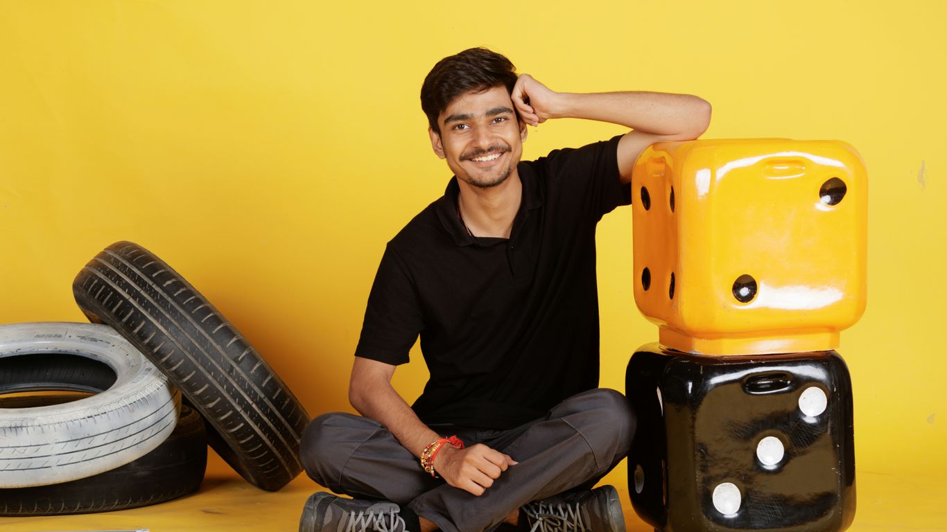 Young man sitting with tires and dice