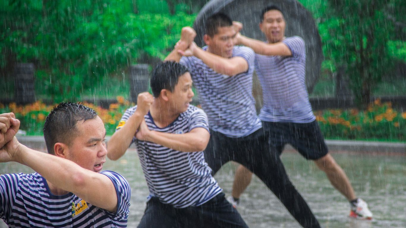 2 boys playing on water fountain during daytime