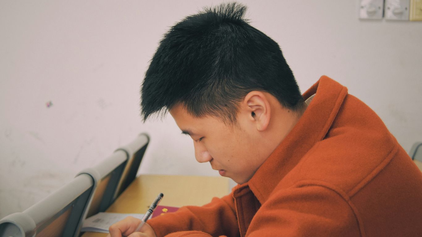 man in orange hoodie using smartphone