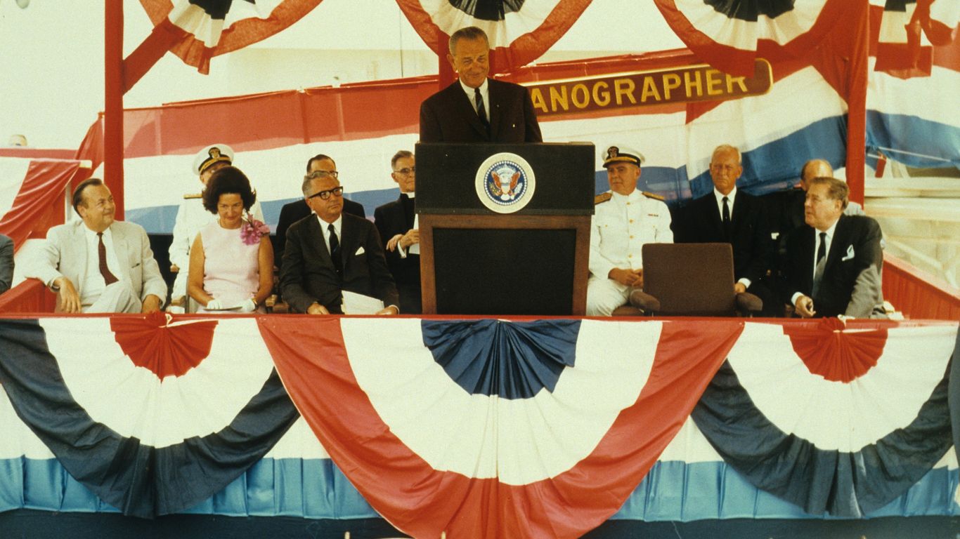 man in black suit standing on red and white flag