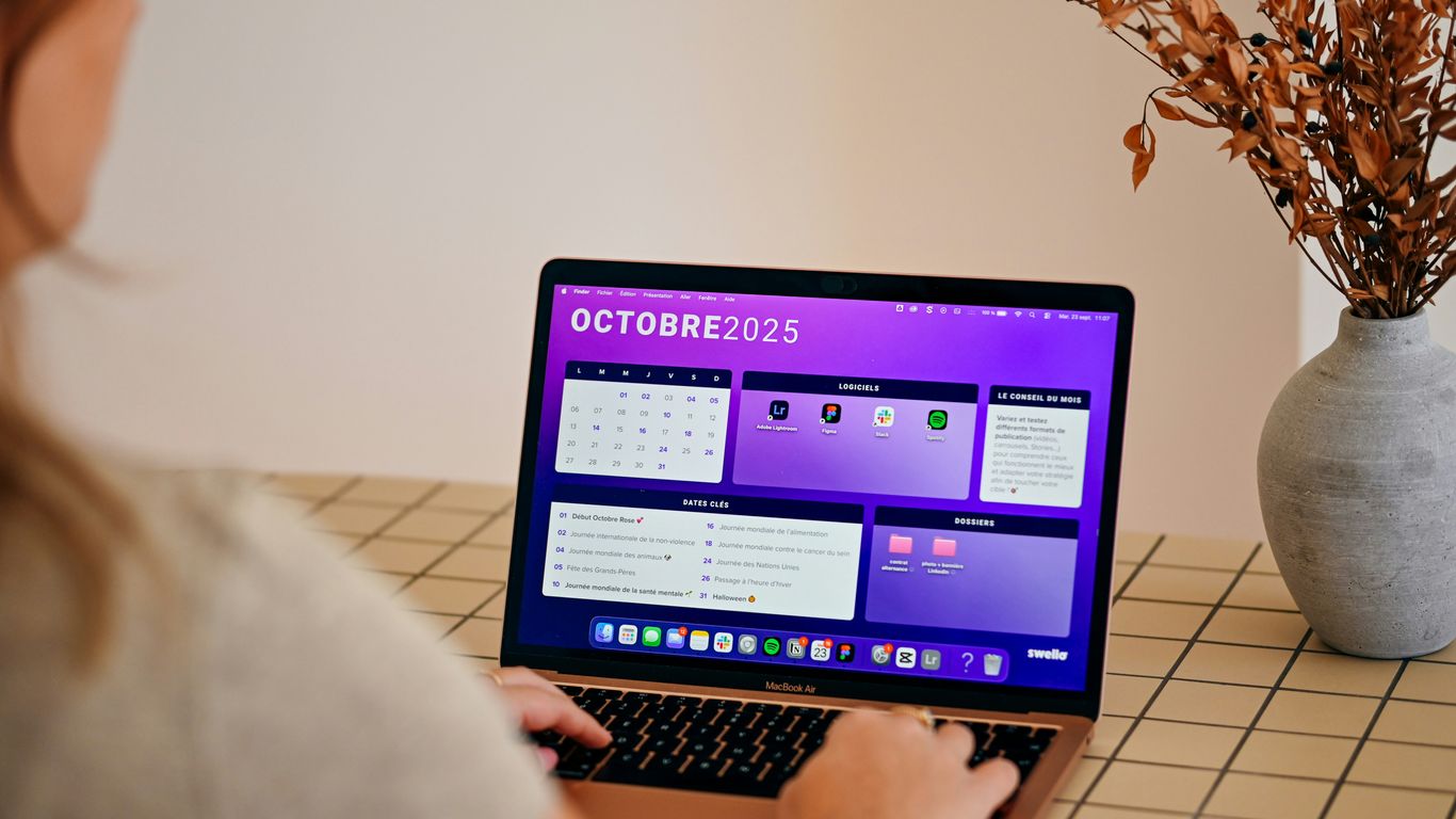 Woman using laptop with october 2025 calendar displayed.