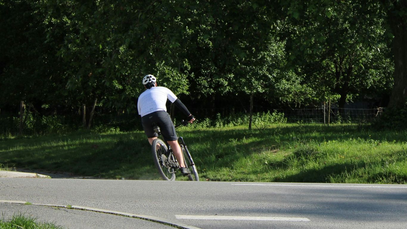 A man riding a bike down a curvy road
