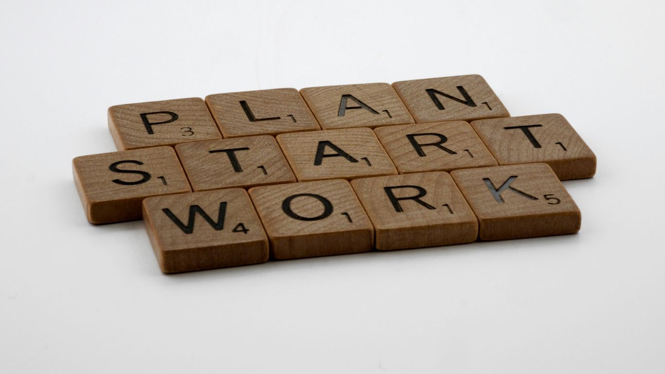 a scrabble of scrabble tiles spelling the words plan, start,