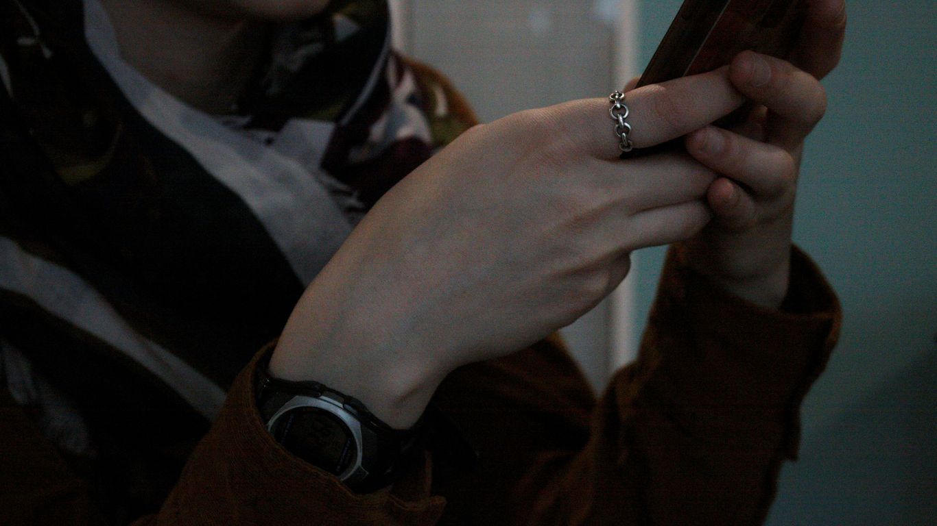 person wearing gold ring and black watch