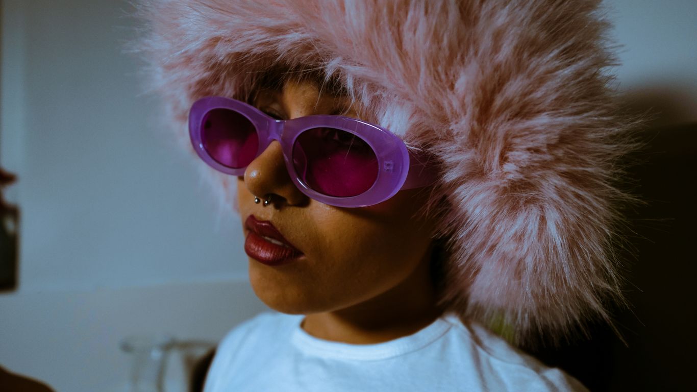 a woman wearing sunglasses and a fur hat
