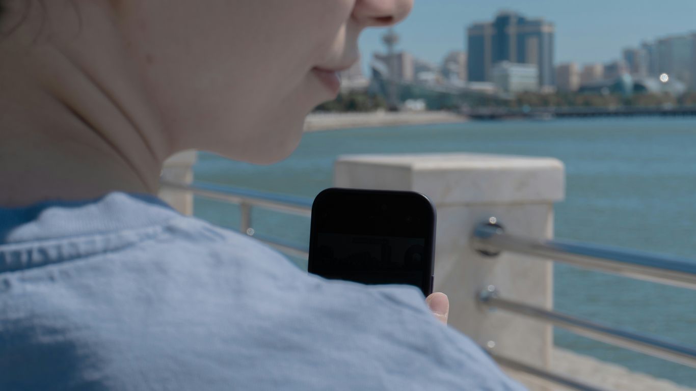 Woman uses her phone with a scenic view.