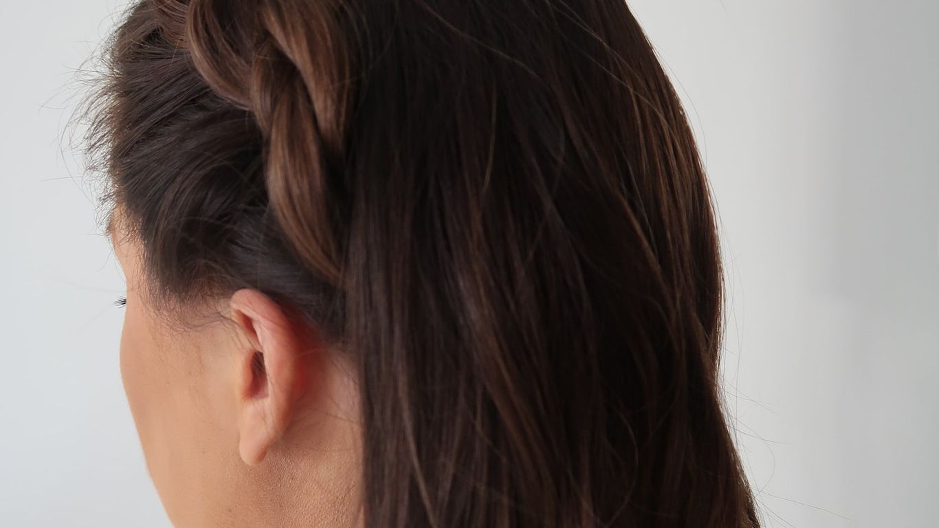 One side of a person's head showing braided hairstyle.