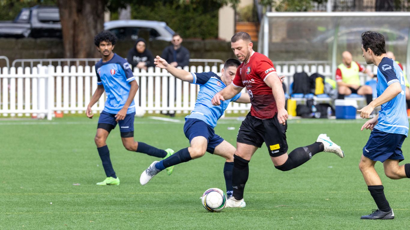 Soccer players competing for the ball on a field.