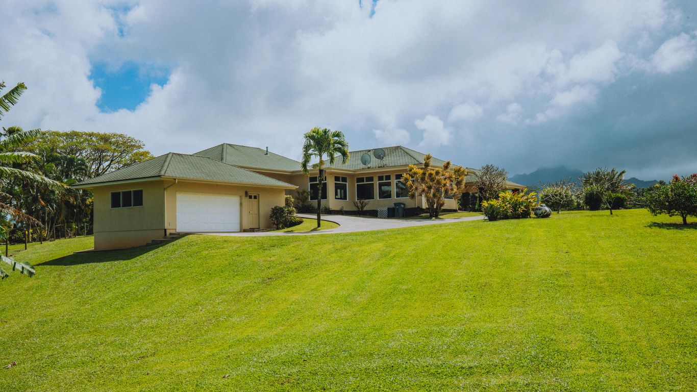 white and brown house on green grass field under blue sky during daytime