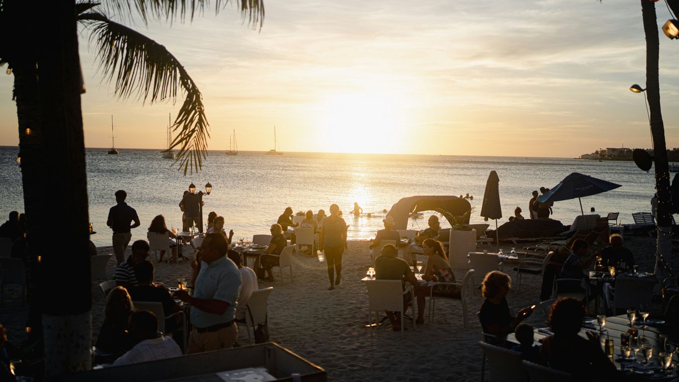 A group of people standing on top of a sandy beach