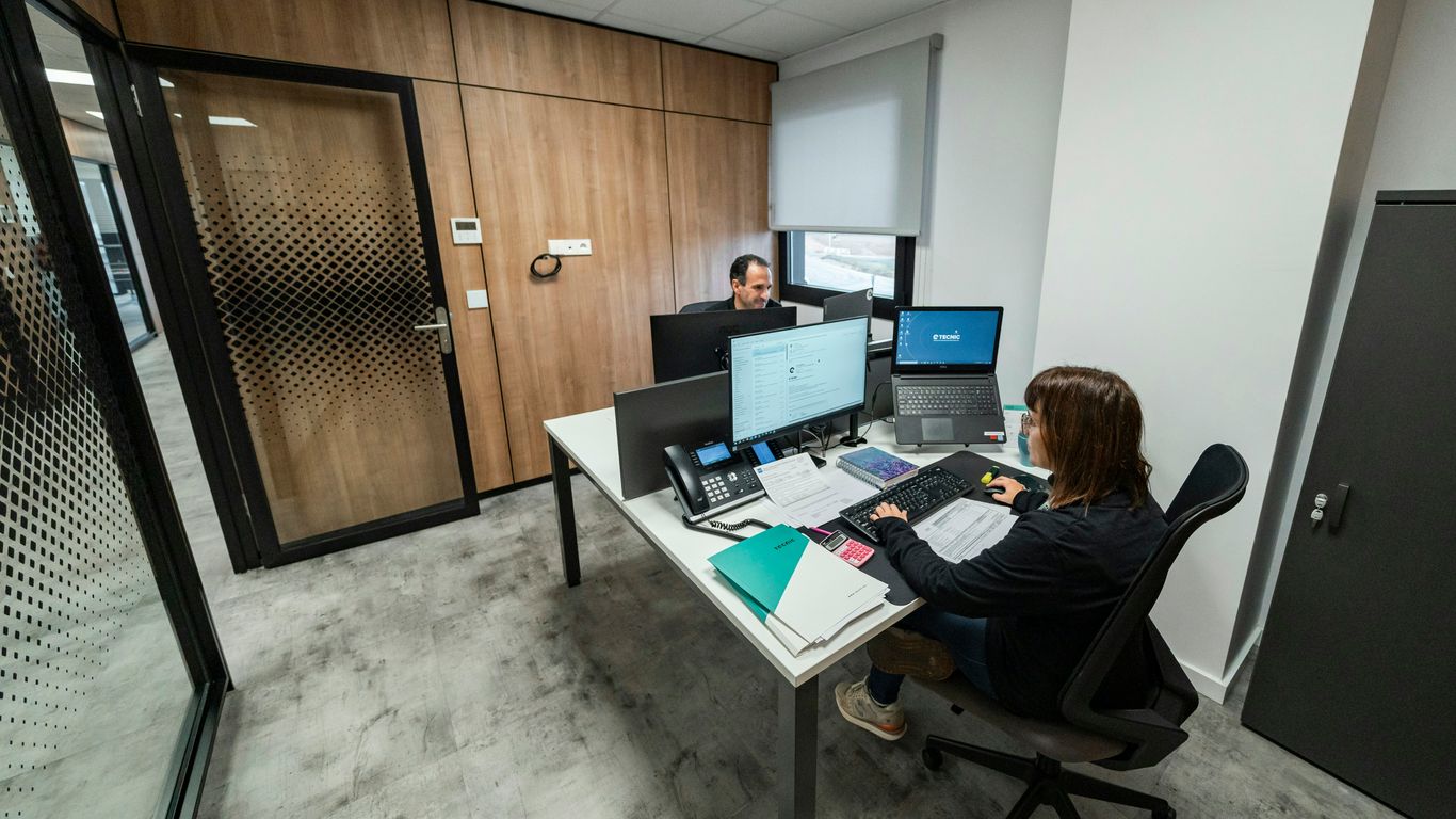 People work at desks in a modern office.