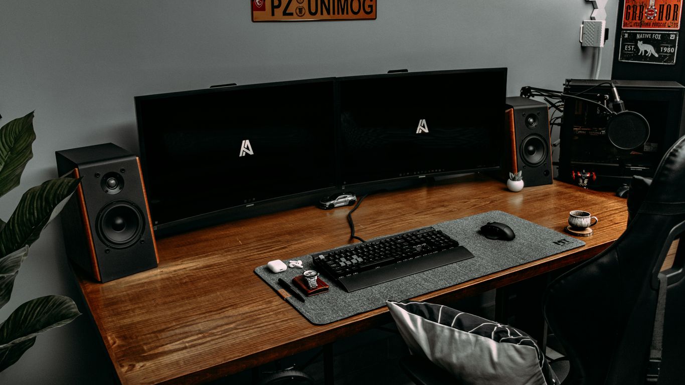 a computer desk with a keyboard and speakers