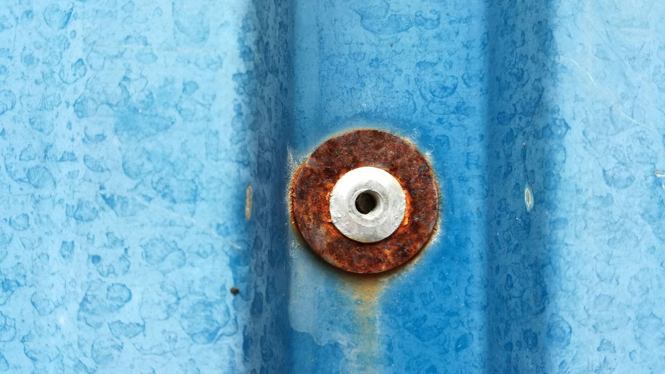 a rusted metal object on a blue surface
