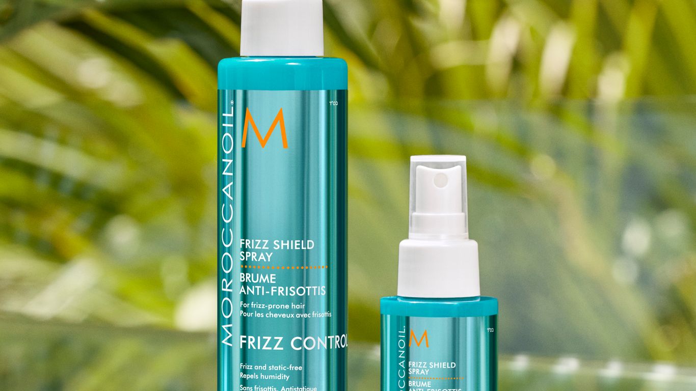 Hair care products displayed with a tropical foliage background.