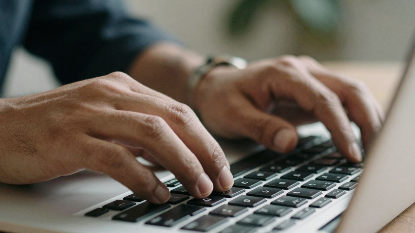 Hands typing on a laptop keyboard for SEO.