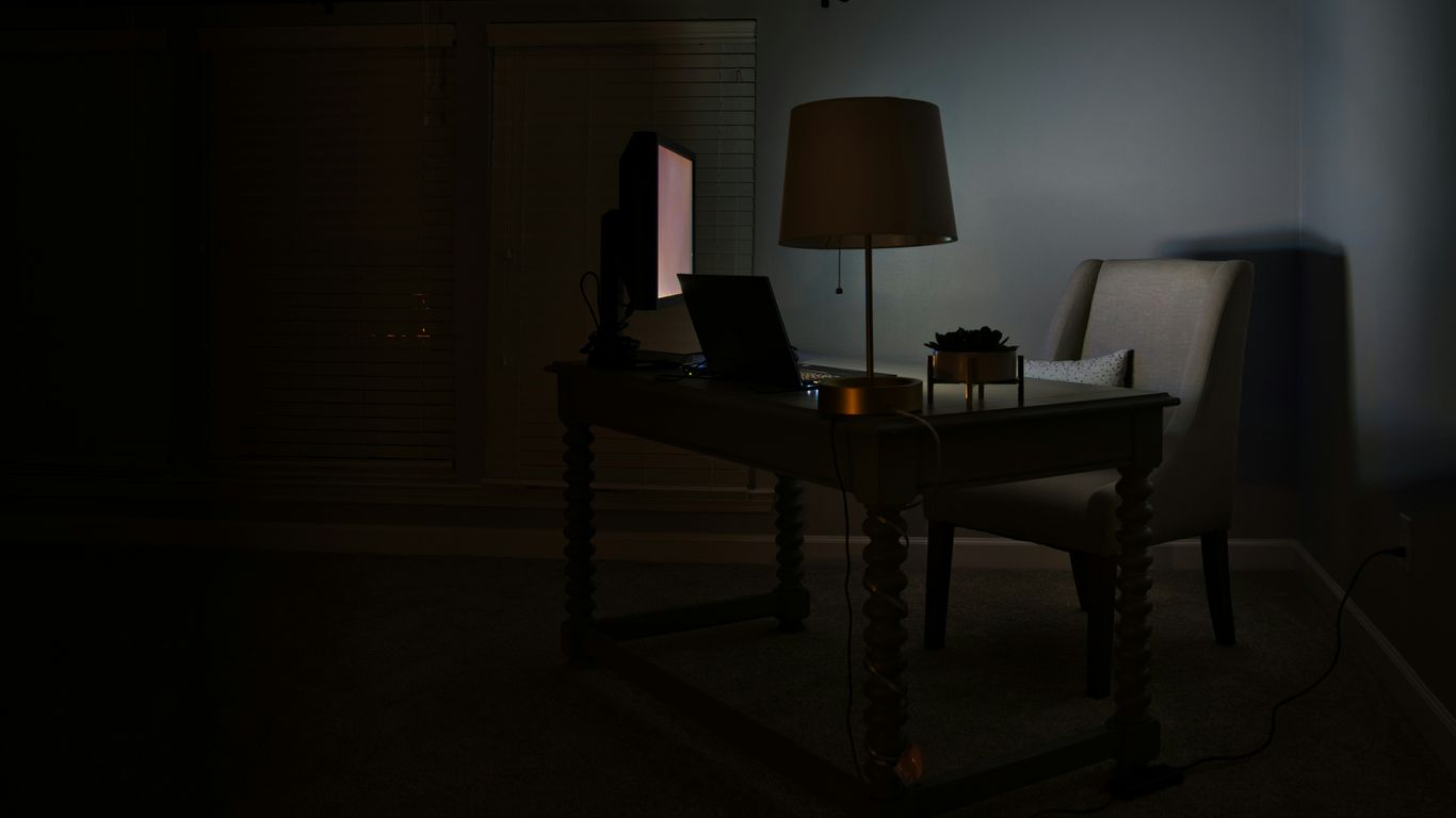 a desk with a lamp and a laptop on it