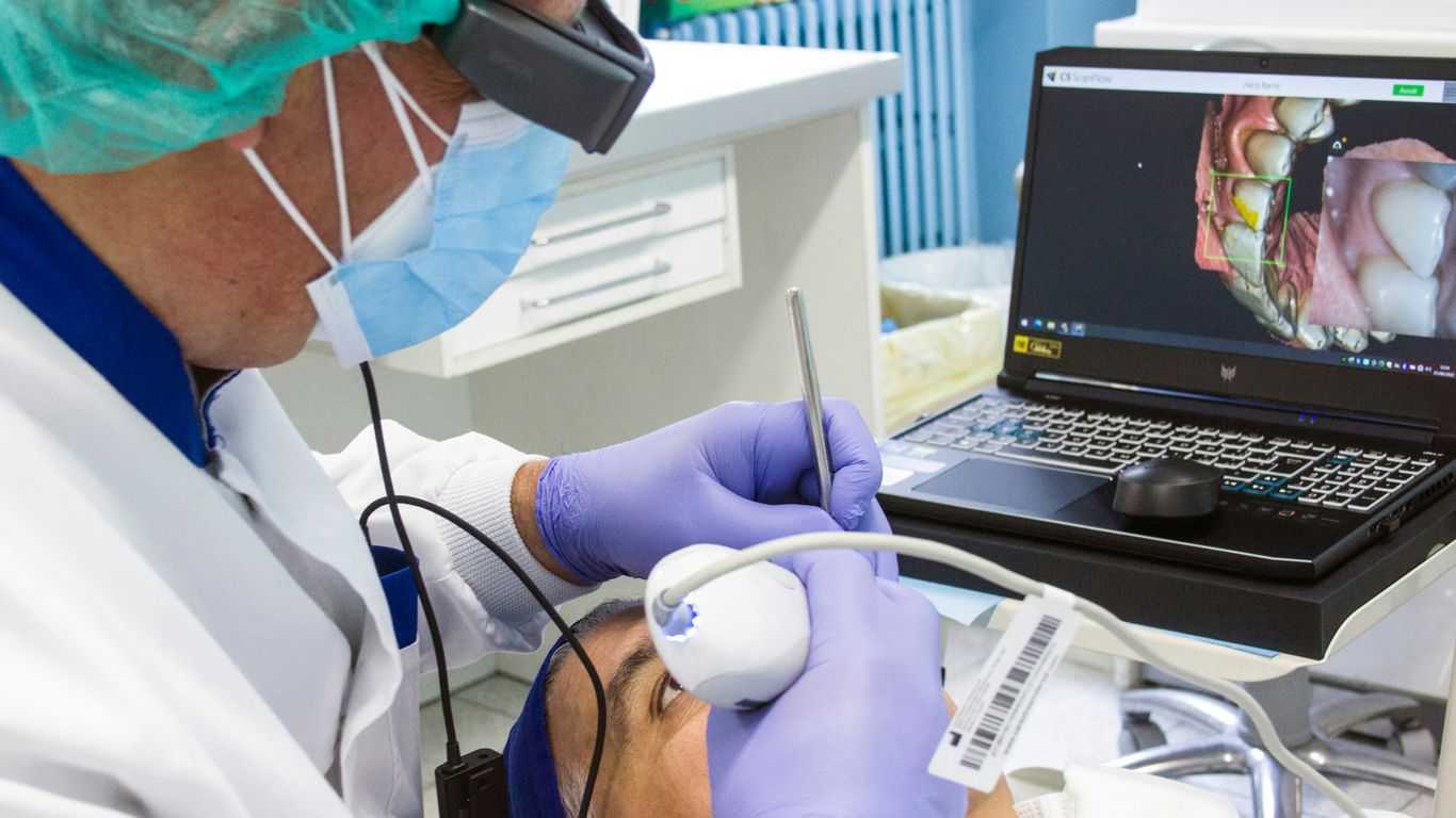 a person in a mask and gloves using a laptop
