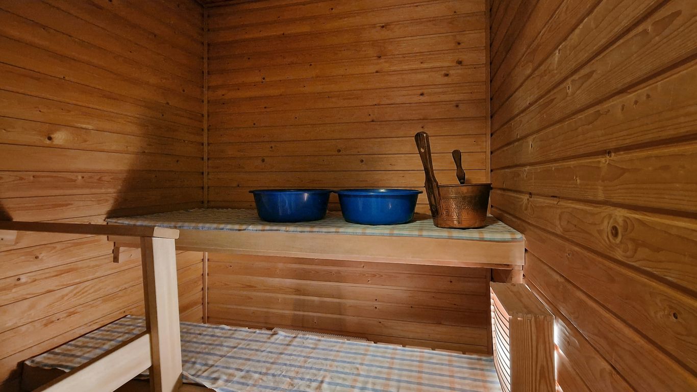 A wooden sauna with two blue bowls on top of it