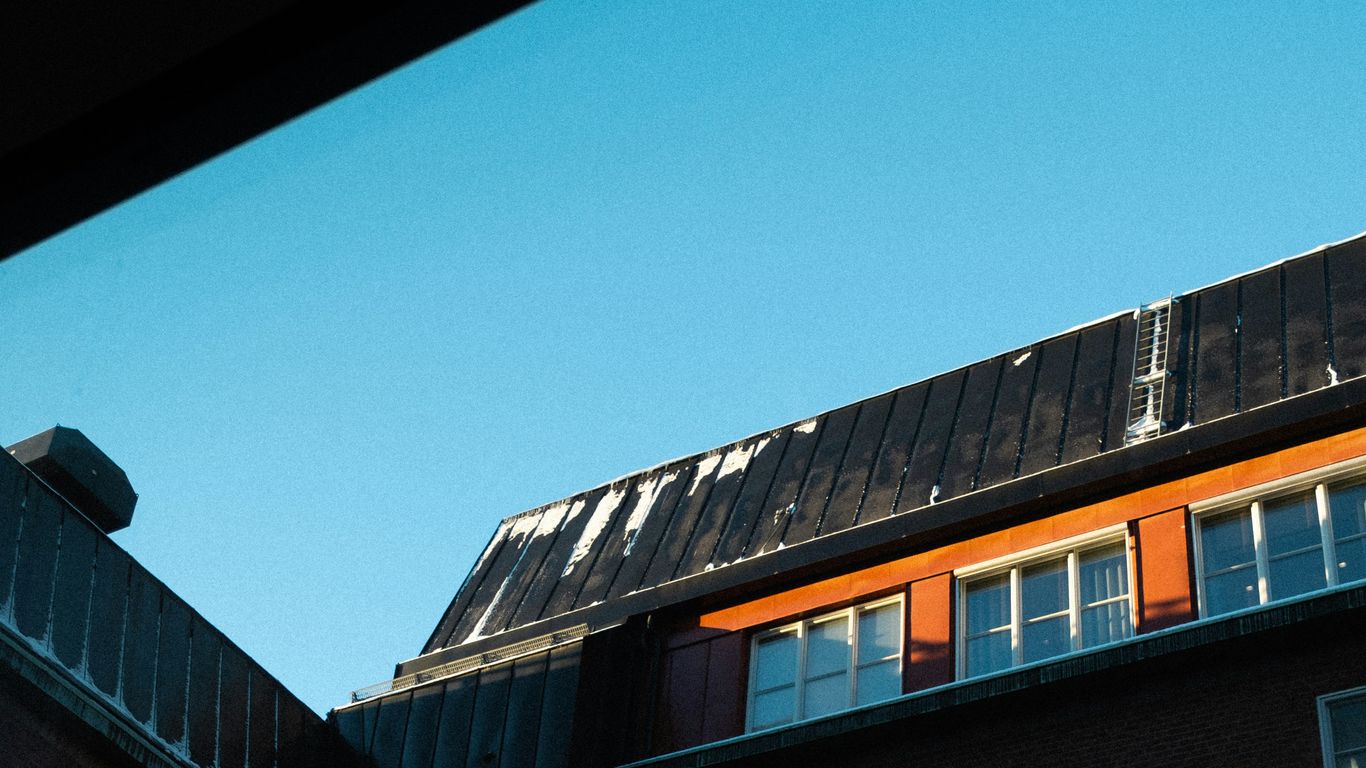 Roof with solar panel installation potential, clear blue sky, emphasizing sunlight exposure for solar attic fan efficiency.