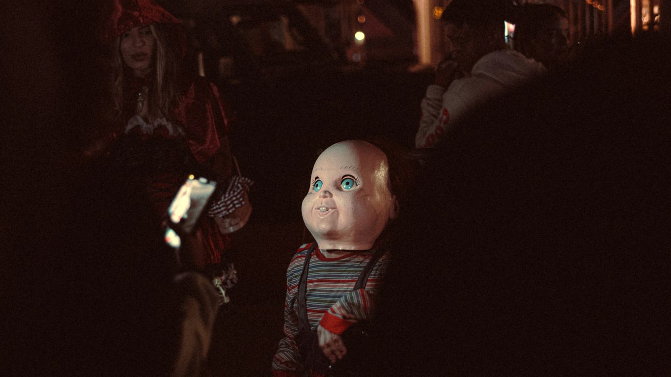 A creepy doll is standing in the dark