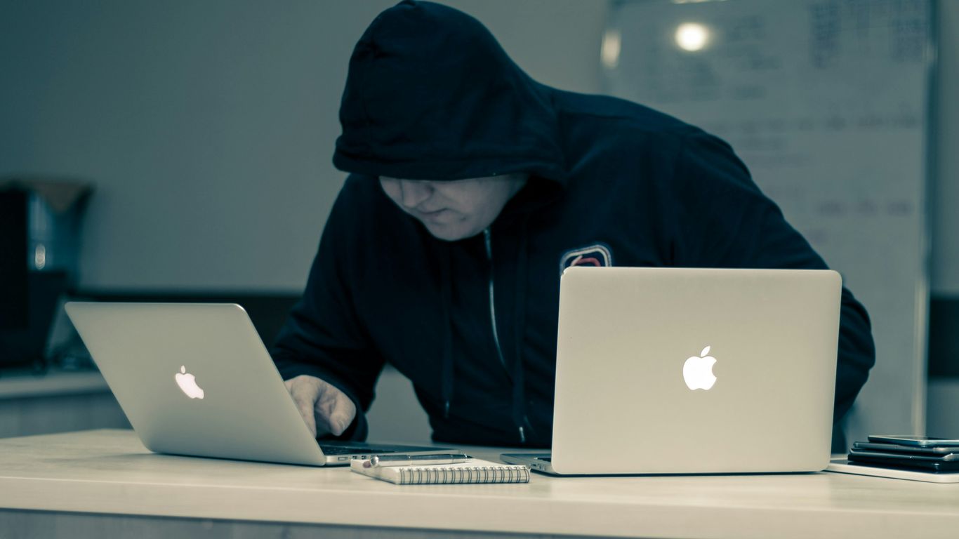 man in black hoodie using macbook