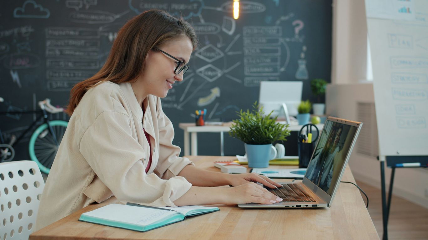 Young woman working on laptop in modern office