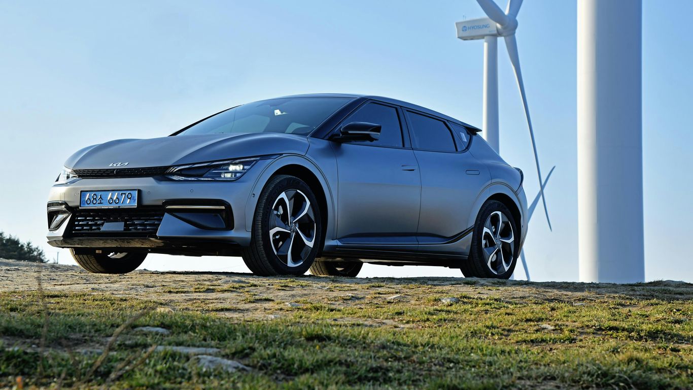 a car parked in front of a wind turbine
