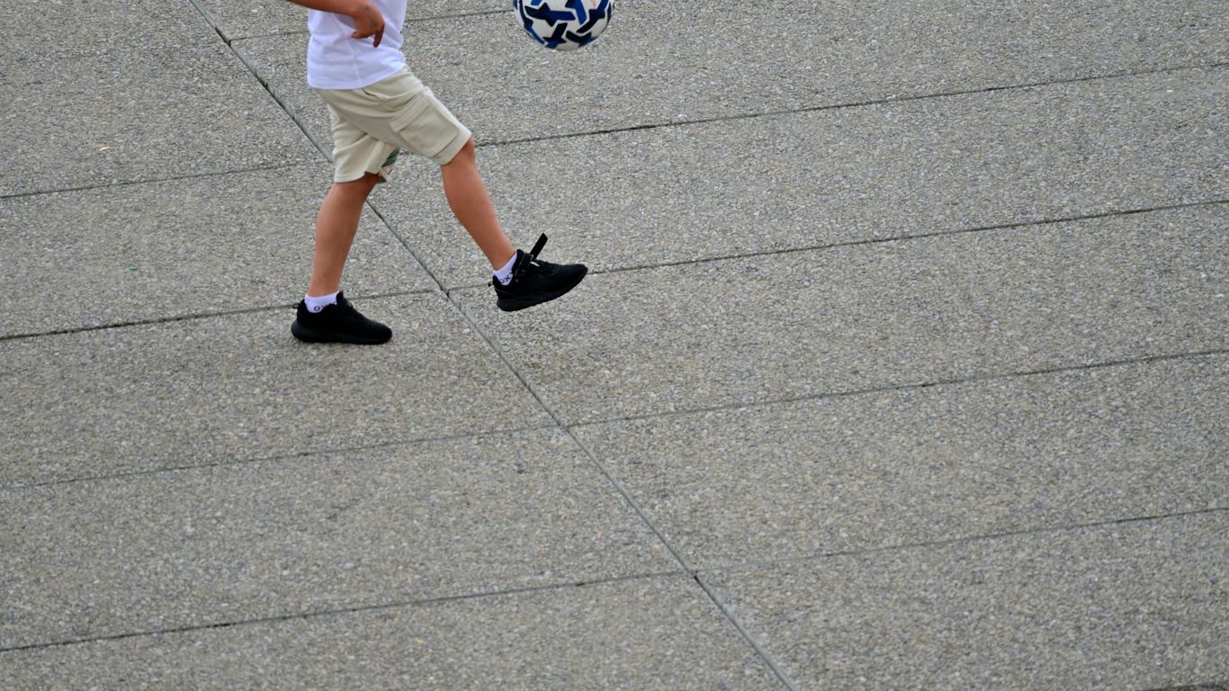 A young boy is kicking a soccer ball