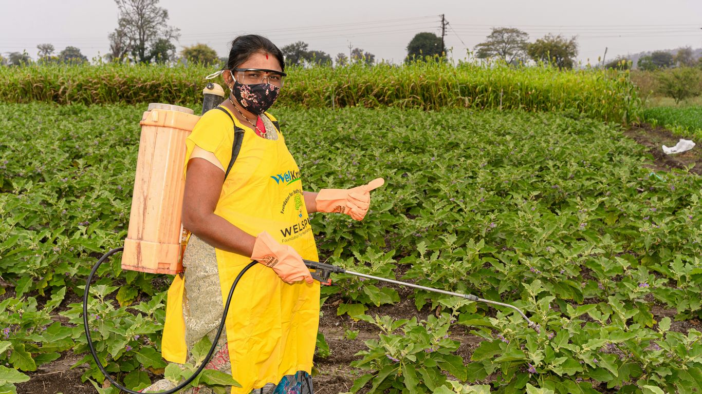 a person in a field with a sprayer