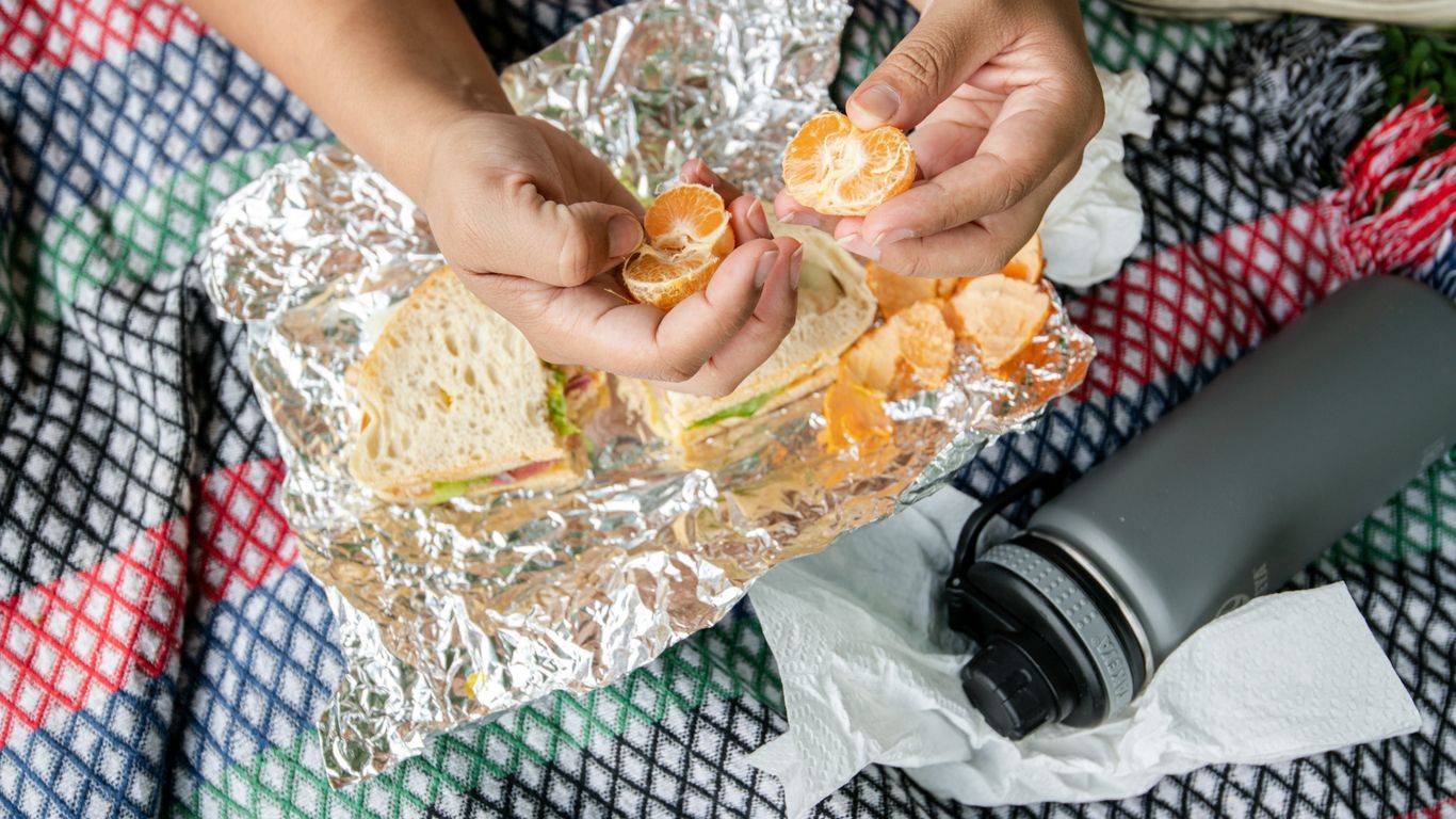 person holding brown bread with orange on top