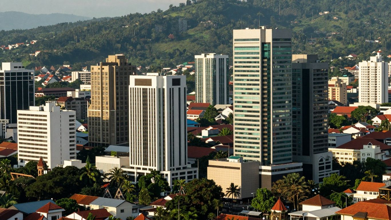Bandung cityscape with modern buildings and green hills.