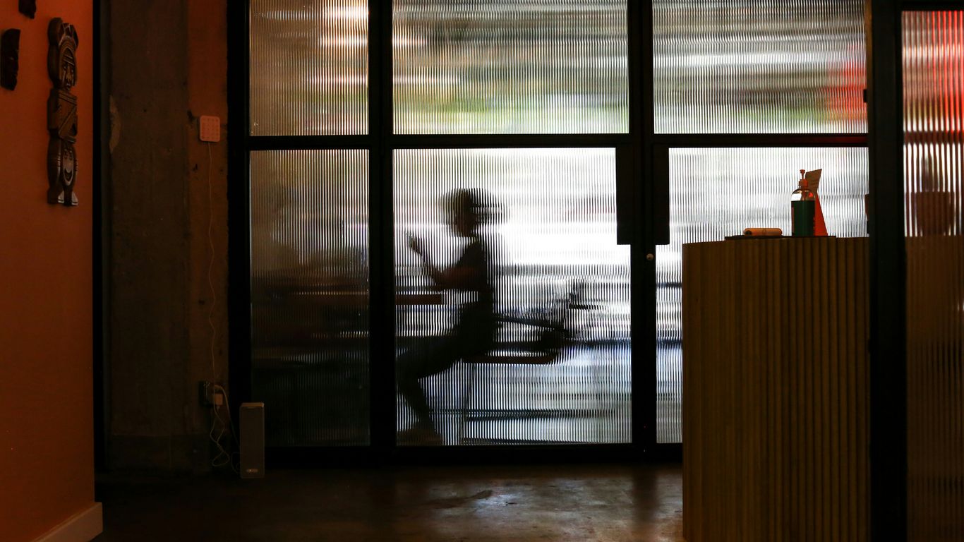 man in white t-shirt standing near window