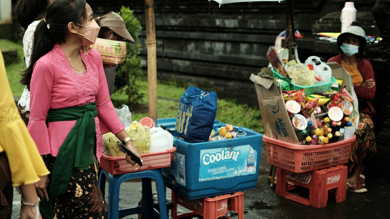a group of people standing around a table filled with food