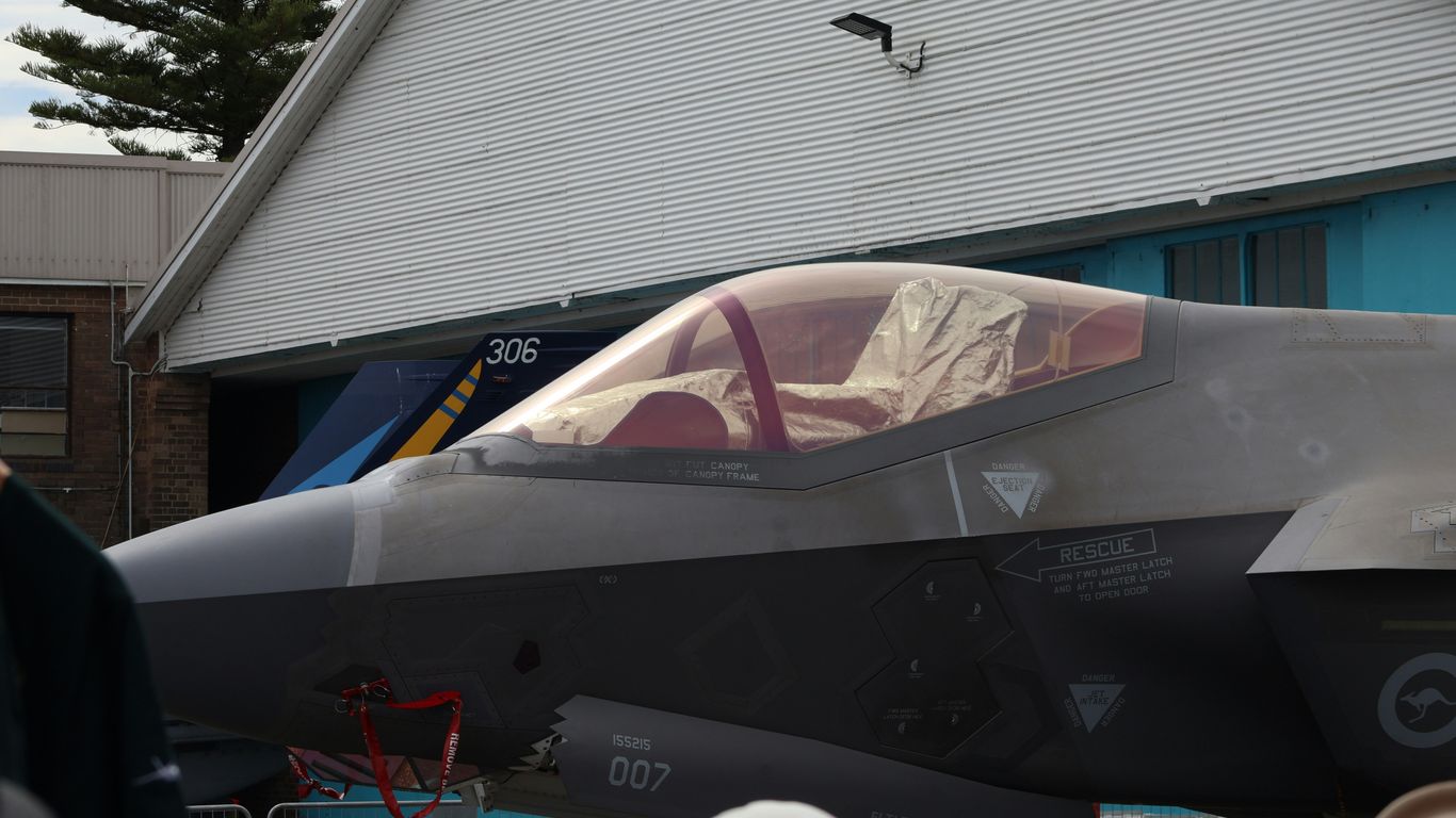 Modern fighter jet cockpit with red interior details.