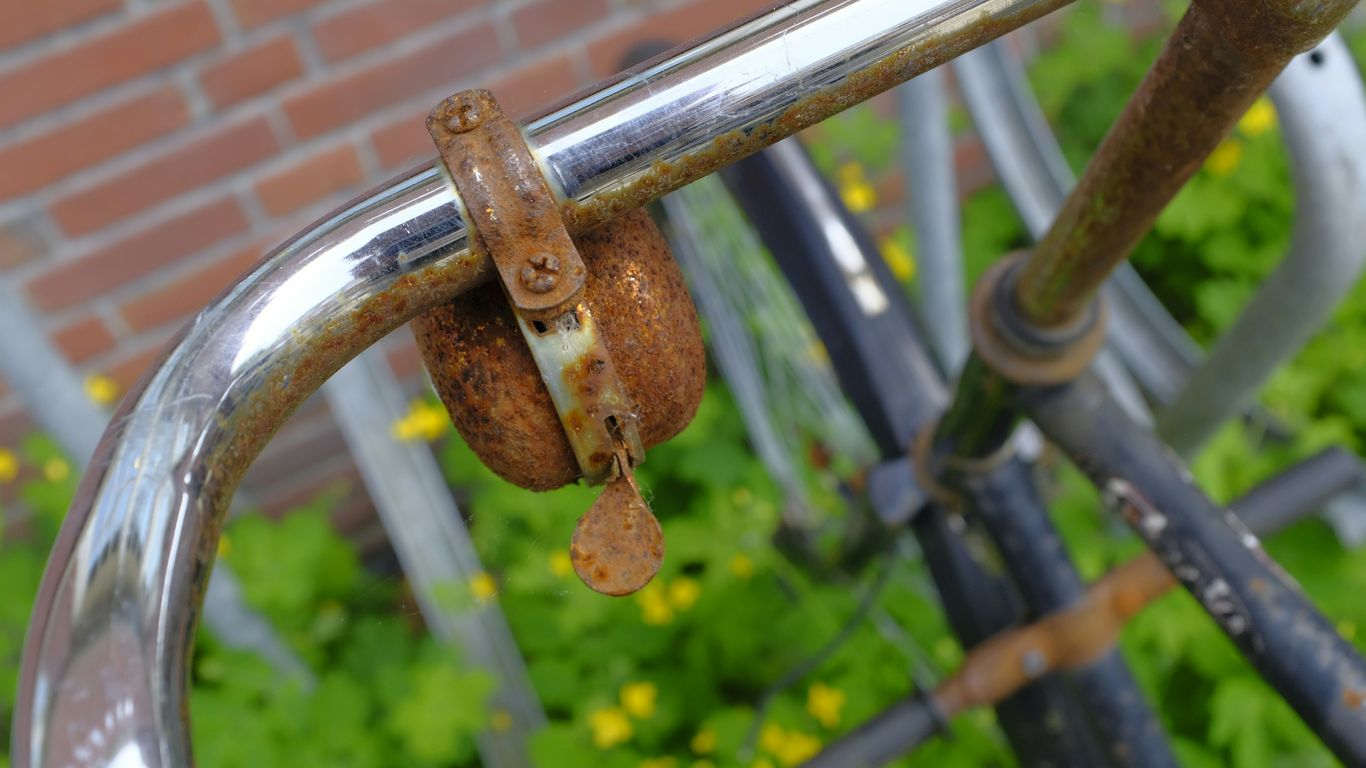 a rusted metal railing with a brick wall in the background