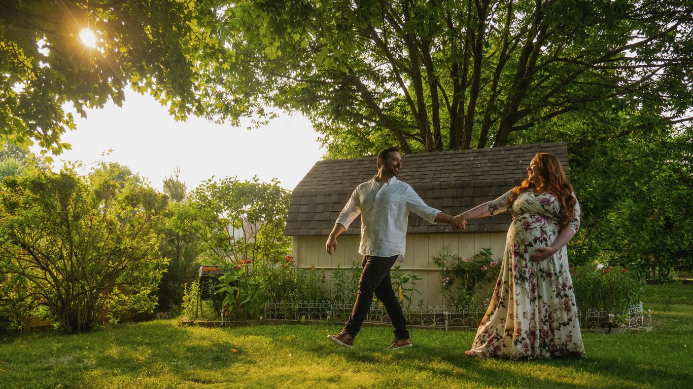 a man and a woman holding hands in front of a house