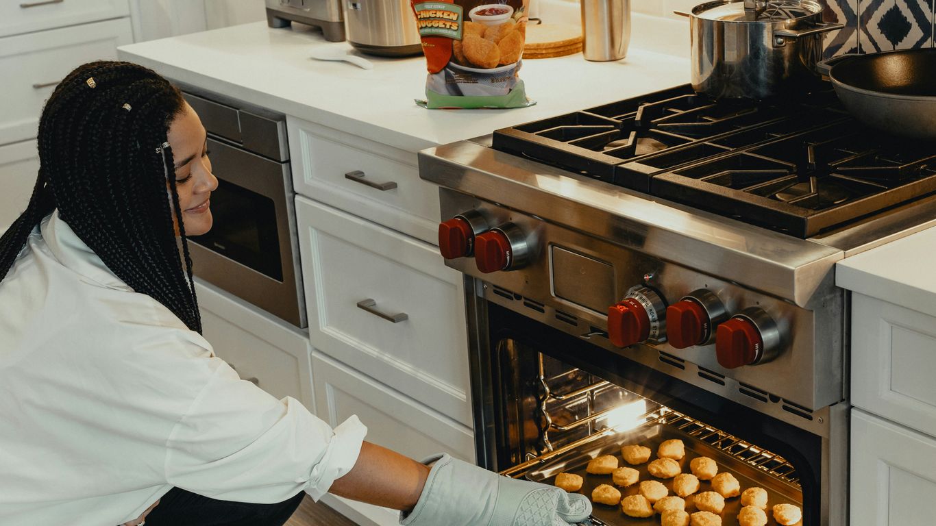 woman in white long sleeve shirt and black and white hijab standing in front of stainless