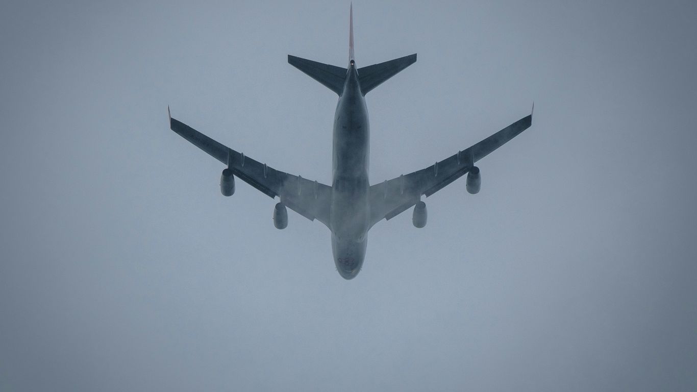 a large jetliner flying through a foggy sky