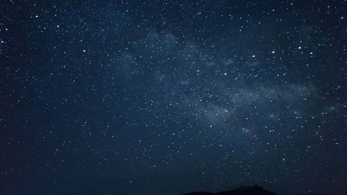 the night sky is filled with stars above a mountain