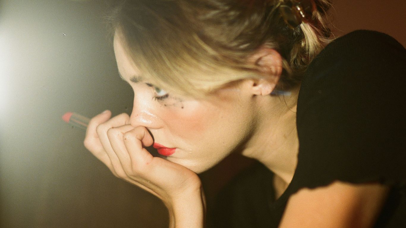 woman holding a red lipstick