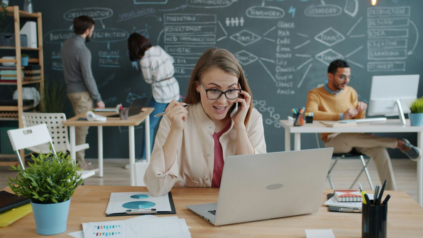 Woman celebrating success while on a business call.