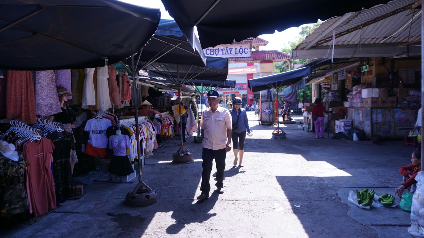 a man walking down a street next to a market