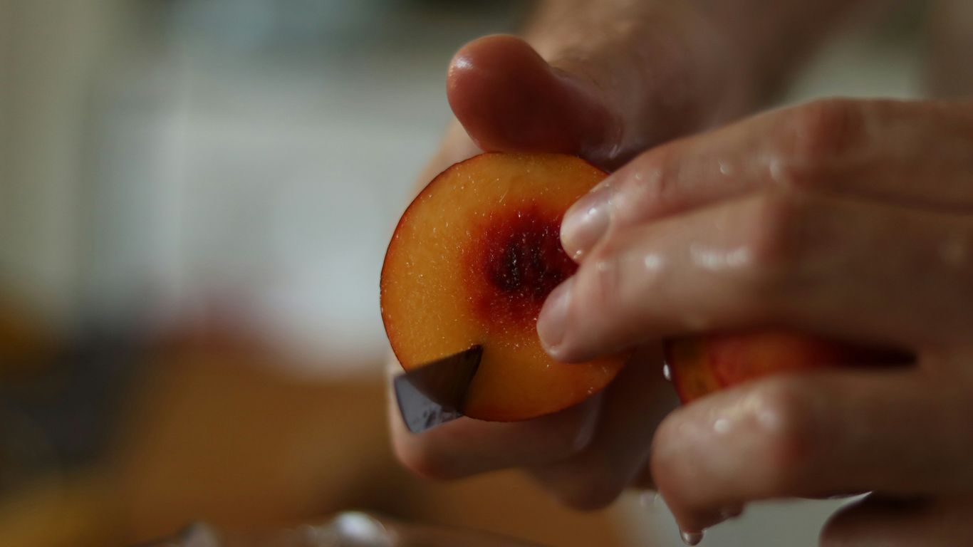 a person holding a piece of fruit in their hand