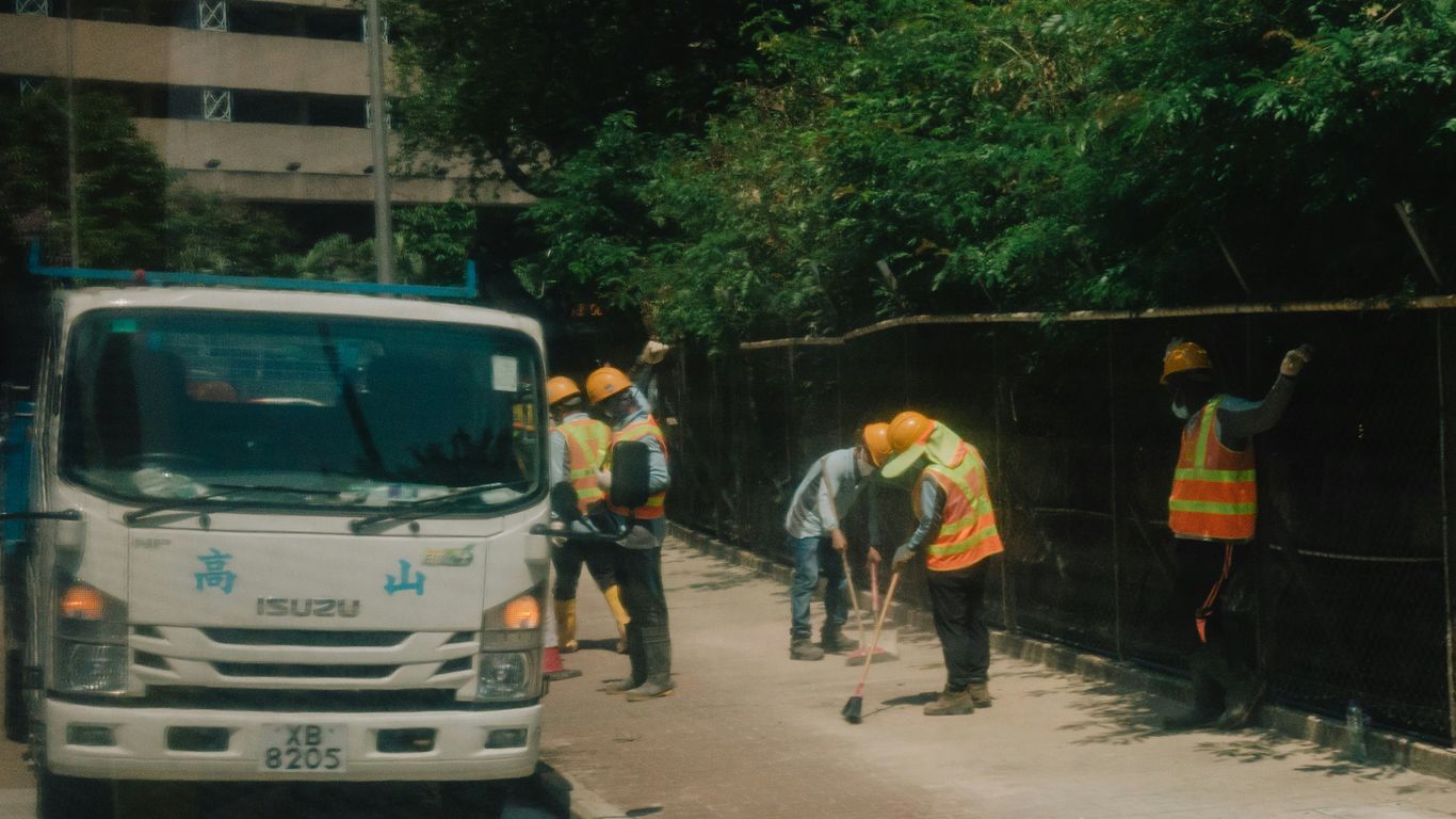 a group of men standing next to a white truck