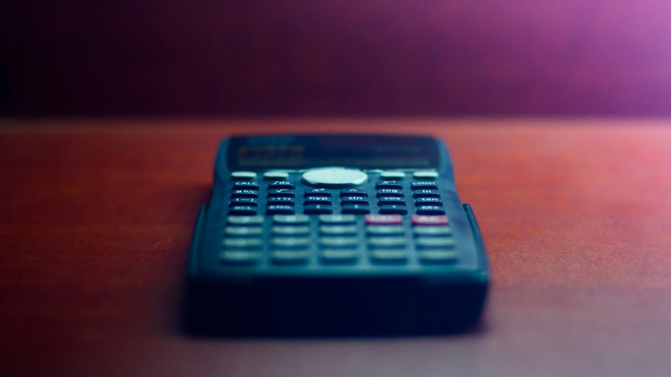 black desk calculator on brown wooden table